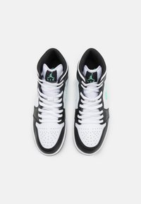 Czarno-białe sneakersy za kostkę z perforowanym noskiem, płaskimi sznurówkami i turkusowymi akcentami. Posiadają wyściełany kołnierz oraz wytłoczone logo.