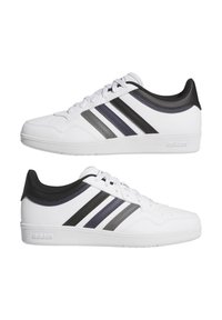 Sneakers bianchi Adidas con strisce nere, grigie e blu navy, lacci bianchi e colletto nero, mostrati dai lati sinistro e destro su sfondo bianco.