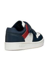Baskets navy et blanches avec une sangle Velcro, dotées d'une touche de rouge, d'un design perforé et d'une semelle en caoutchouc texturé. Marque Geox visible.
