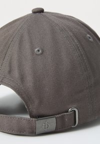 Gray baseball cap with a textured fabric, adjustable strap, and metal hardware. Features a rounded crown and a small button at the top.