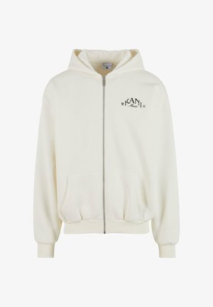 Krémová mikina s kapucňou a zipsom, prednými vreckami, rebrovanými manžetami a lemovaním, s čiernym logom "KANI Music" na hrudi.