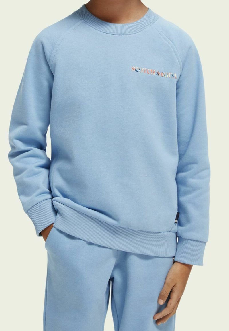 Felpa azzurro chiaro realizzata in morbido tessuto, con polsini e orlo rigati. Logo "Scotch & Soda" in lettere multicolori sul davanti.