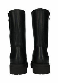Botas de tobillo de cuero negro con una textura suave, que presentan un cierre de cremallera, punta redondeada y suela de goma resistente, vistas desde la parte posterior.