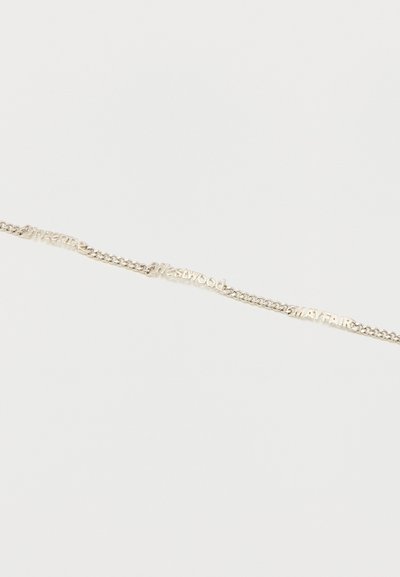 Λεπτό βραχιόλι με αλυσίδα από ασήμι με κομμένες λέξεις "Vivienne Westwood MAYFAIR" συνδεδεμένες κατά μήκος του σε λευκό φόντο.