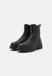 Bottines en cuir noir avec des zips latéraux doubles, un dessus texturé, un bout arrondi et une semelle en caoutchouc épaisse avec un léger talon.