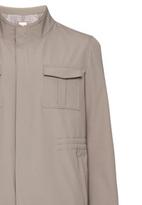 Beige jacka med ståkrage, två framfickor och dekorativ söm. Tillverkad av ett slätt tyg med en subtil lyster.