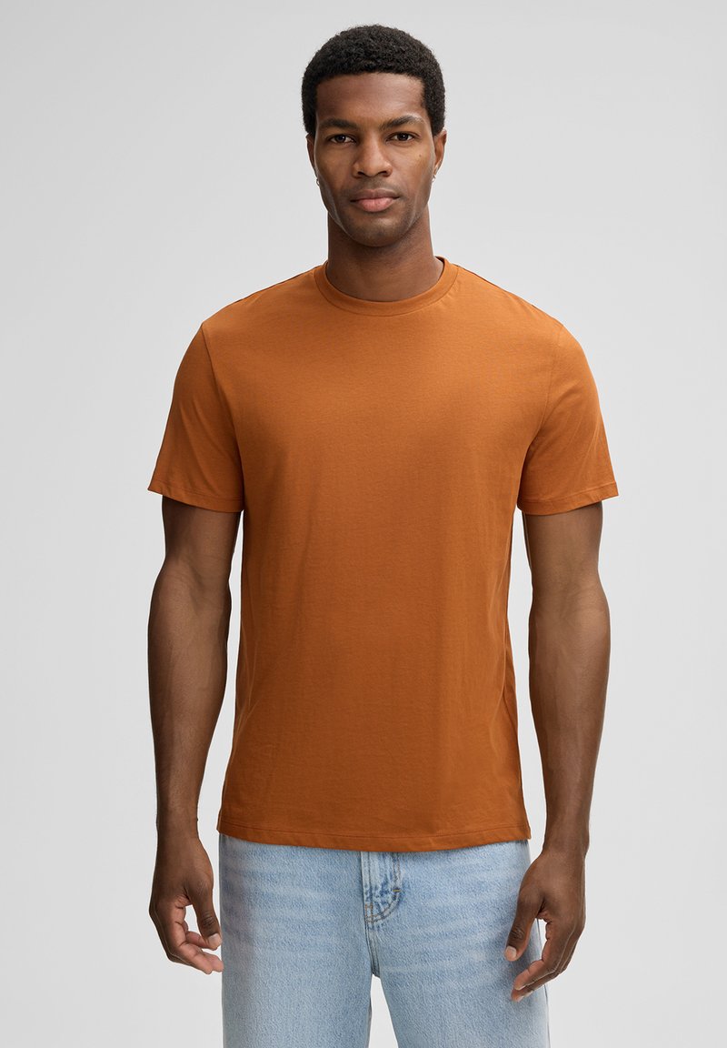 Oranje T-shirt met korte mouwen van een gladde katoenmix, voorzien van een klassieke ronde hals en een ontspannen fit. Gecombineerd met licht gewassen denim.