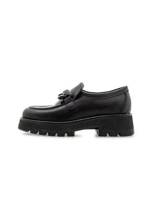 Zapato de cuero negro con punta redondeada, una correa decorativa y una suela de goma gruesa y texturizada. Diseño minimalista con sutiles detalles de costura.