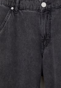 Vaqueros de denim negro con una textura suave, diseño de cinco bolsillos, cierre de botón plateado y acentos cosidos en la parte delantera y trasera.