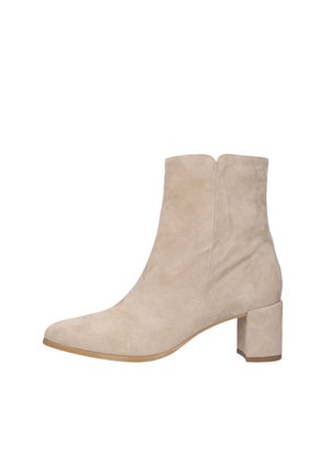 Bottine en daim beige avec talon bloc et bout pointu, fermeture éclair latérale et semelle lisse.