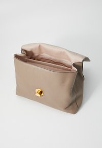 Beige leather handbag with a textured finish, featuring a gold-tone button closure and an interior zip pocket.