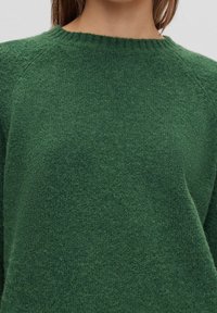 Green knitted sweater with a crew neckline, soft texture, and a relaxed fit. Features raglan sleeves and a subtle, fuzzy finish.