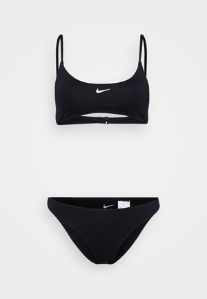 Svart bikini-set bestående av en bralette-topp med justerbara remmar och spänne, ihopparat med matchande lågriskade bikiniunderdelar.