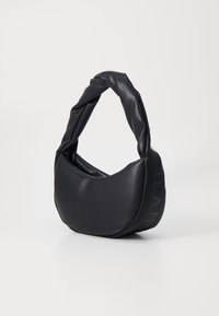 Fekete műbőr kézitáska csavart fogantyúval, kerek formával, sima textúrával és dombornyomott felirattal az egyik oldalán.