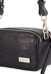 Schwarze Leder-Crossbody-Tasche mit Krokodil-Prägung, silberfarbener Hardware, Reißverschluss und einem Logo-Plättchen auf der Vorderseite.