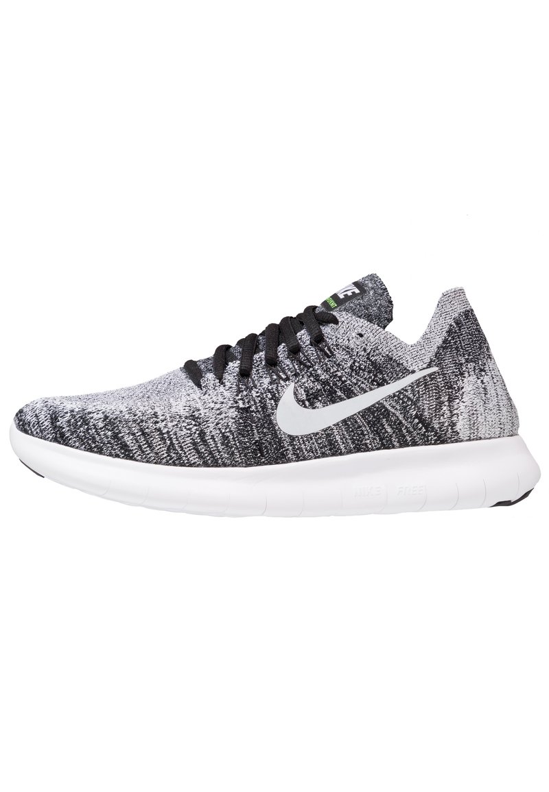 Scarpe sportive a maglia bianco e nero con suola bianca, lacci neri e logo swoosh argentato di lato. Parte superiore testurizzata per traspirabilità.