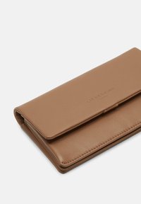 Prostokątny, składany brązowy portfel ze skóry z widocznym przeszyciem i wytłoczonym na klapie przedniej napisem marki "LIEBESKIND BERLIN".