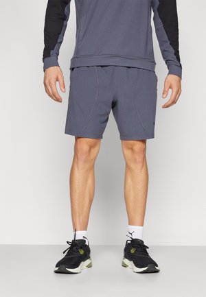 Gray athletic shorts with side seams, paired with a matching gray top and black sneakers. The fabric appears lightweight and smooth.