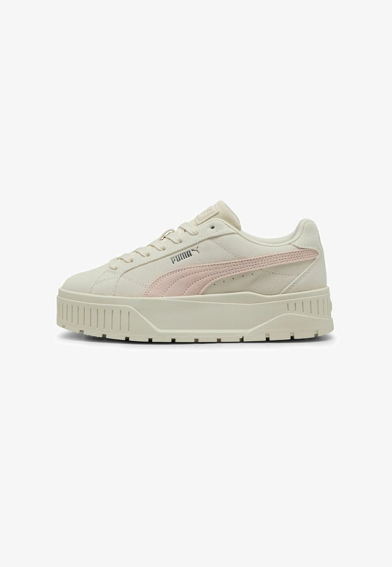 Puma Sneaker in Creme und zartem Rosa, mit einem glatten Lederoberteil, runder Zehenform und einer dicken, strukturierten Sohle mit horizontalen Rillen.