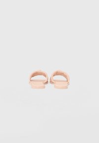 Pink rubber slide sandals with a minimalist design, featuring a cushioned footbed and open toe. The straps are smooth and slightly rounded.