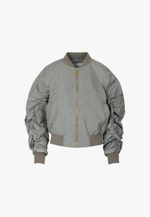Šedá bomber bunda se zapínáním na přední zip, na rukávech mačkaný detail, žebrované manžety a lem, a kulatý výstřih. Zlaté kovové doplňky.