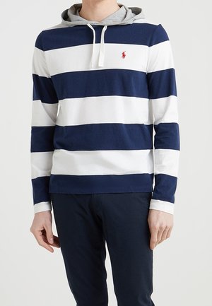 T-shirt à manches longues rayé bleu marine et blanc avec capuche grise, en tissu doux. Présente un petit logo rouge sur la poitrine.