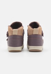 Des chaussures mi-hautes violettes et beige avec des sangles réglables, en matériau synthétique texturé, un col rembourré et des semelles en caoutchouc beige avec un logo en relief.