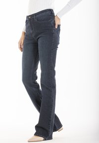 Jean en denim bleu marine avec une coupe droite, doté d'une fermeture à bouton devant, de passants de ceinture et d'un design classique à cinq poches.