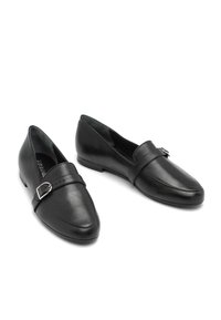 Een paar zwarte leren instaploafers met zilveren gespdetail op een witte achtergrond, in een hoek gepositioneerd om zowel de bovenkant als de zijkant te tonen.