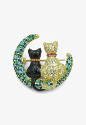 Spilla in tonalità dorata con un gatto nero e un gatto tempestato di cristalli seduti insieme su una mezzaluna decorata con gemme blu e verdi.
