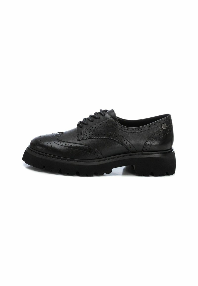 Scarpe brogue nere in pelle con punta rotonda, dettagli wingtip e una suola in gomma spessa e testurizzata. Includono lacci e accenti perforati.