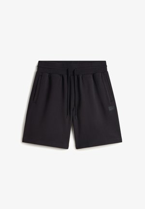 Black sweat shorts made of cotton blend fabric. Features an elastic waistband with drawstring, side pockets, and a small logo patch.