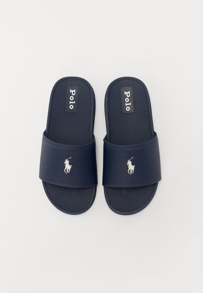 Sandalias de playa de color azul marino hechas de goma con una plantilla texturizada, que destacan por una correa ancha y un logo bordado de un pony.