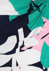 Textil med ett blommönster i gröna, marinblå, rosa och vita färger; tyg med en slät textur och samlade designdetaljer.
