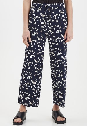 Marinblå vida byxor med liten blommönster i vitt och beige. Har ett elastiskt midjeband med dragsko. Lättviktsmaterial.