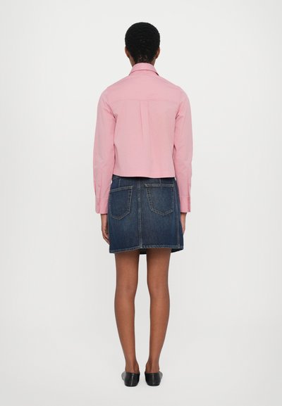 Lys rosa skjorte med strukturert krage, kombinert med et denim A-linje skjørt med baklommer og råsøm.