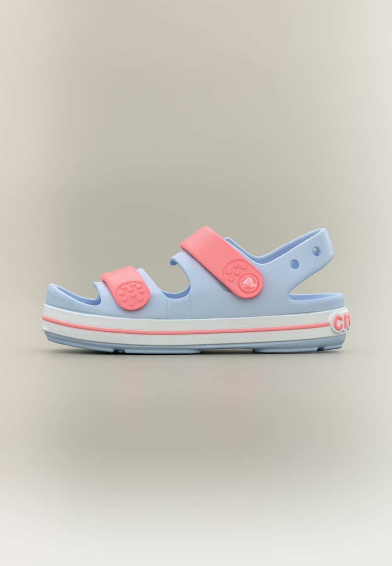 Ανοιχτό μπλε σανδάλι με ροζ ρυθμιζόμενους ιμάντες, λευκή σόλα με ροζ περιθώριο και τρύπες αερισμού σε ουδέτερο φόντο.