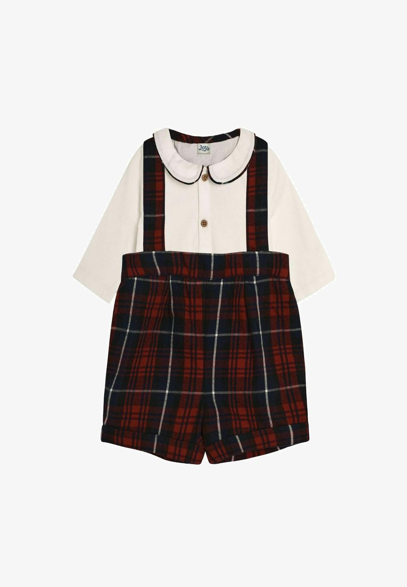 Chemise blanche à manches longues avec un col arrondi, assortie à un short à carreaux rouge et marine, doté de bretelles et d'une fermeture à boutons.
