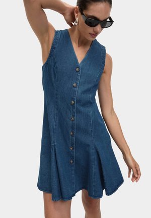 Denimkleid mit tiefem V-Ausschnitt, ärmellosem Design, Knopfverschluss vorne und ausgestelltem Rock. Die Farbe ist Mittelblau mit einer glatten Textur.