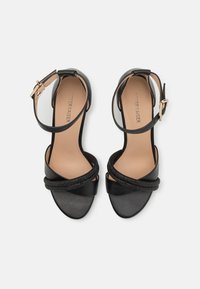 Schwarze Leder-Sandalen mit einem Riemendesign, Schnalle am Knöchel und strukturierten, geflochtenen Akzenten auf der Vorderseite. Glatte Innenauskleidung.