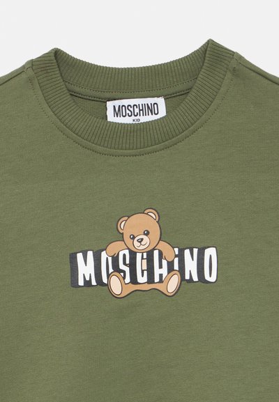 Φούτερ σε ελαιί πράσινο χρώμα με καρτούν αρκουδάκι και τη λέξη "MOSCHINO" με έντονα  μαύρα και λευκά γράμματα. Υφή με ριμπ στον λαιμό.