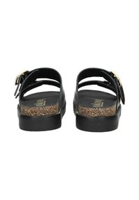 Sandalias negras con dos correas ajustables, que presentan un acento de corcho en la plataforma y un detalle de hebilla dorada. Textura suave y mate.