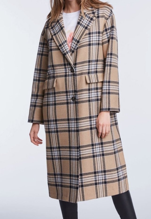 Manteau en laine à carreaux beige avec motifs noirs et blancs, design oversize, col cranté, deux poches frontales et fermeture à double bouton.