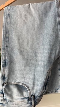 Lyseblå denimjeans med en falmet vask, med en frontlomme og søm detaljer langs midjen og sidesømmene.