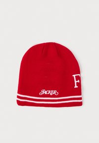Gorro de punto rojo con textura acanalada. Presenta letras blancas "JACKER" y una franja decorativa blanca alrededor del borde. Diseño de copa redondeada.