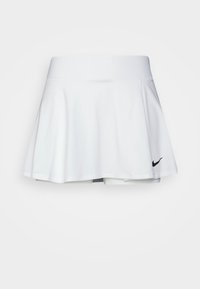 Falda deportiva blanca con un diseño A-line fluido, cinturilla elástica y discreto logo negro de Nike en el lado izquierdo. Textura de tela suave.