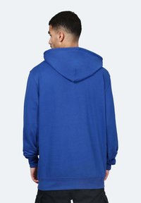 Felpa blu in cotone con cappuccio spazioso, maniche lunghe e vestibilità rilassata. Presenta polsini e orlo a costine, texture liscia e design minimale.