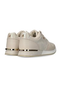 Bežové tenisky s texturovanou bočním panelem, kovovými zlatými akcenty a polstrovaným jazykem a límcem pro pohodlí. Gumená podrážka pro trakci.