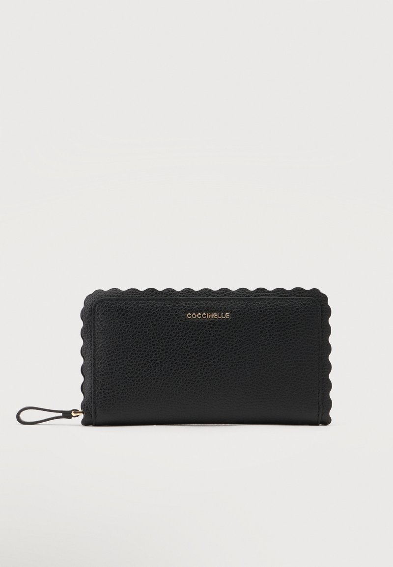 Portefeuille en cuir noir texturé avec des bords festonnés, tirette de fermeture éclair dorée et logo COCCINELLE doré sur le devant.