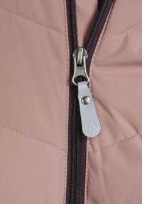 Tessuto trapuntato rosa con cerniera. Tirante della cerniera in metallo argentato e linguetta in tessuto grigio. Accenti cuciti e traccia della cerniera viola scuro.